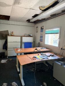Büro von Pure Selection mit heruntergebrochener Deckenverkleidung, Trümmerstücke liegen auf den Schreibtischen