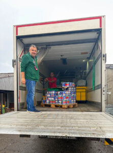 Zwei Männer sichern nach dem Unwetter Paletten mit Tomatenkonserven von Pure Selection im LKW, den Marinello zur Verfügung gestellt hat