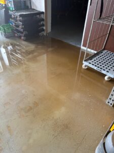 Braunes Wasser steht auf dem Boden im Lager von Pure Selection nach dem Unwetter