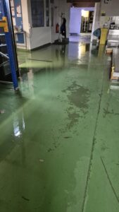 Wasser steht auf dem grünen Hallenboden bei Pure Selection